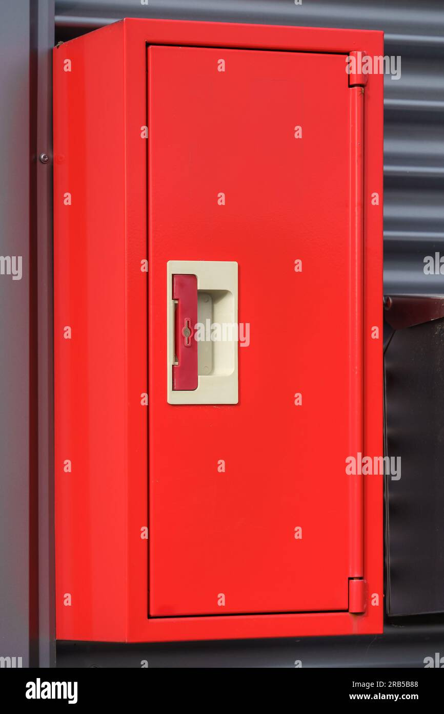 Red fire extinguisher box on a metal wall. Stock Photo