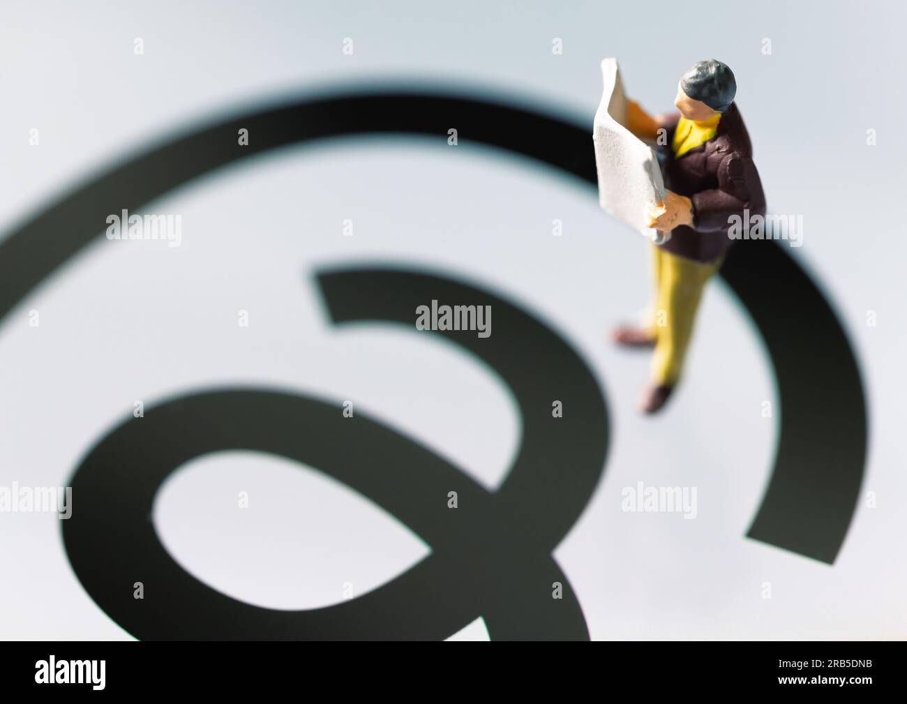 Ankara-Turkey:July 07, 2023: Man figurine reading newspaper while standing on Threads app logo on screen. The new social media application by Meta. Stock Photo