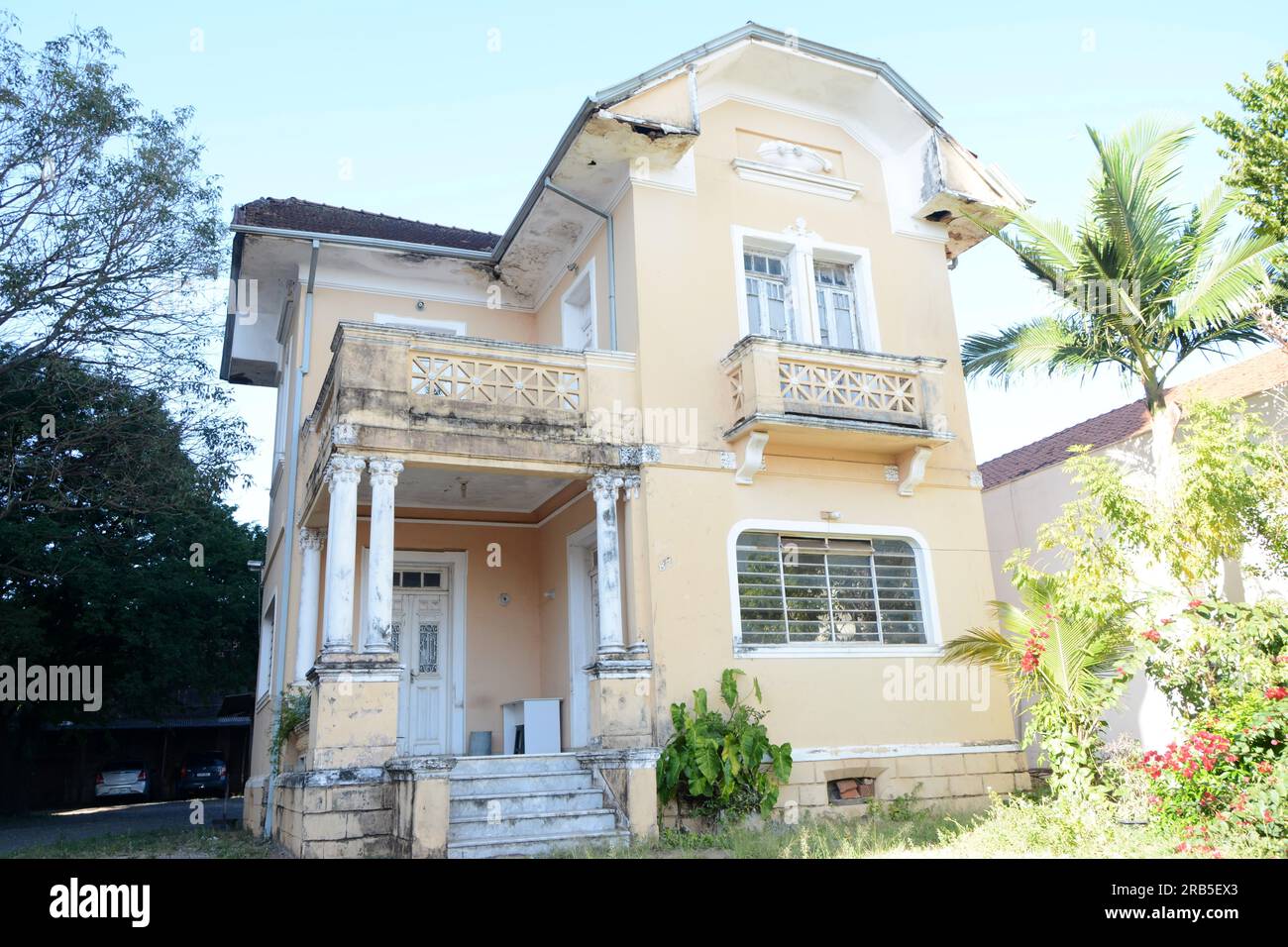 Facade of an old mansion in the interior of Brazil looking from the front with parked cars in the background Stock Photo