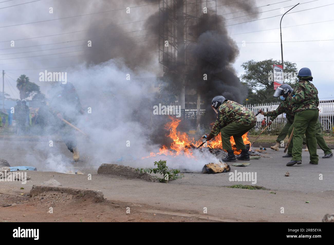 Nairobi, Kenya. 07th July, 2023. Anti-riot police officers remove burning tires that were lit by protesters during an anti-government protest dubbed 'Saba Saba' along Jogoo Road in Nairobi. Credit: SOPA Images Limited/Alamy Live News Stock Photo