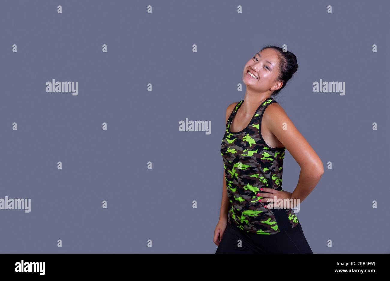 young chinese woman posing in sportswear on gray background Stock Photo