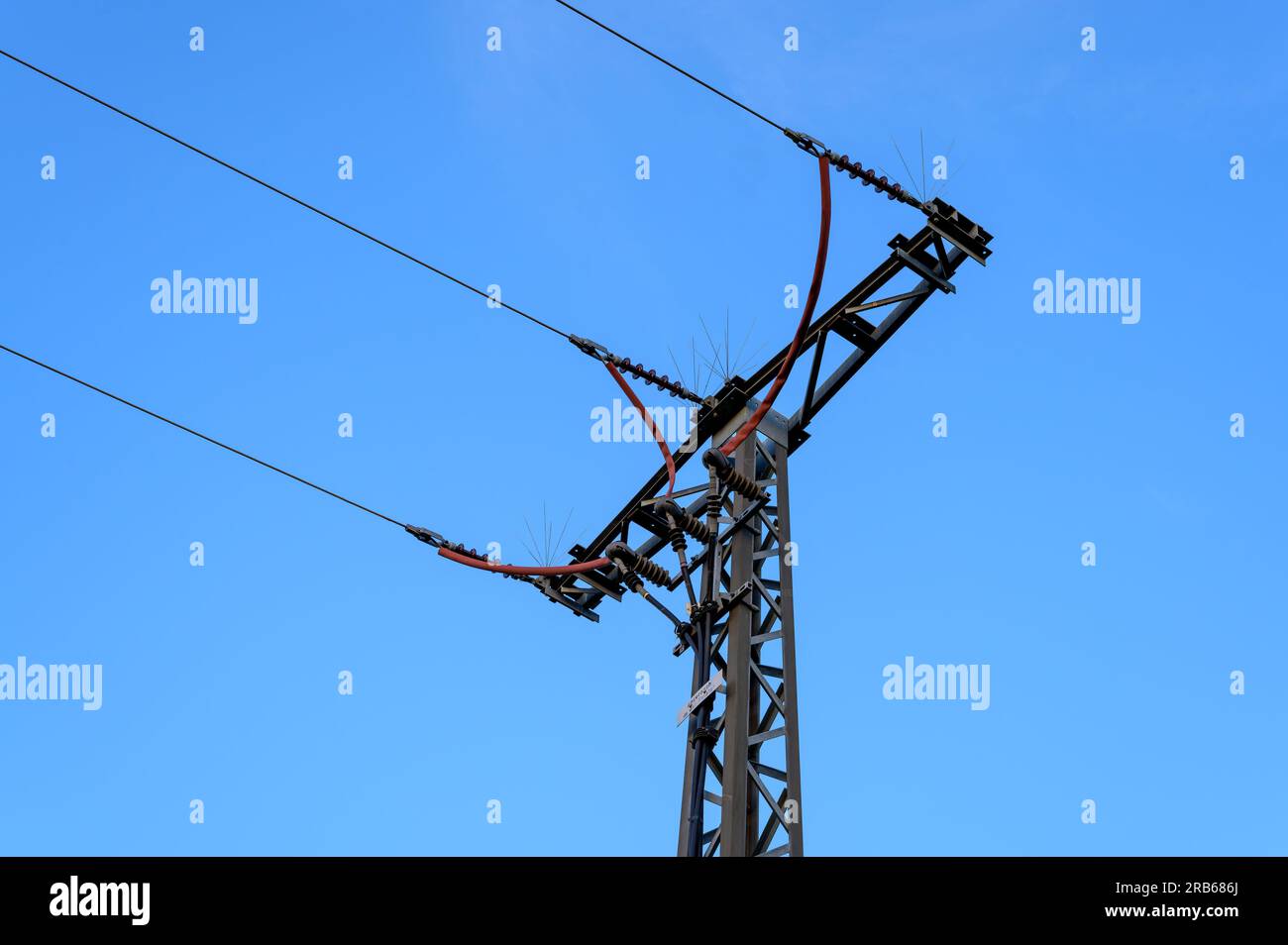 A three phase power line pylon terminates into a ground cable with anti