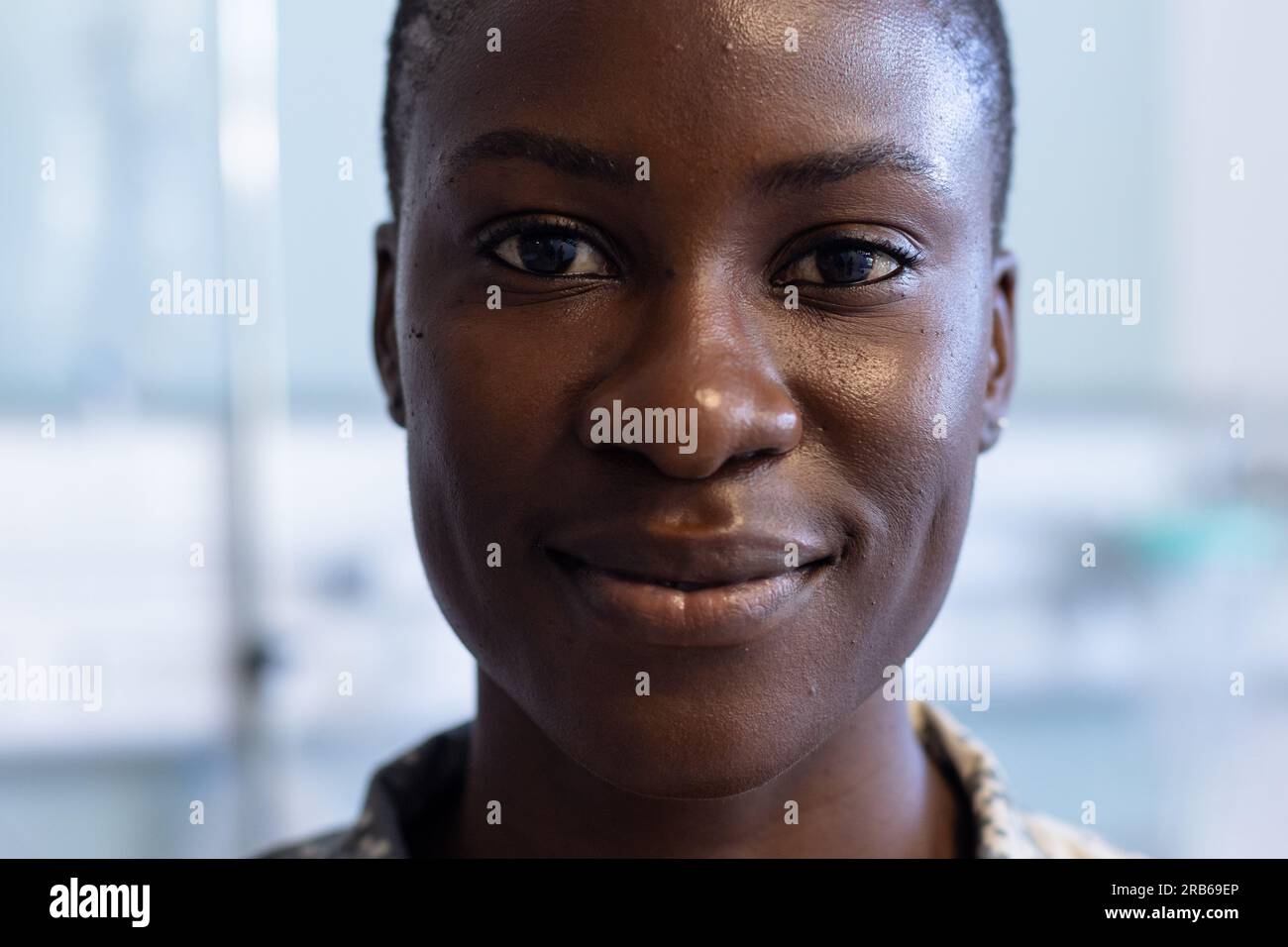 Portrait of happy african american female soldier wearing military uniform smiling at hospital. Hospital, medicine, healthcare, healthcare services an Stock Photo
