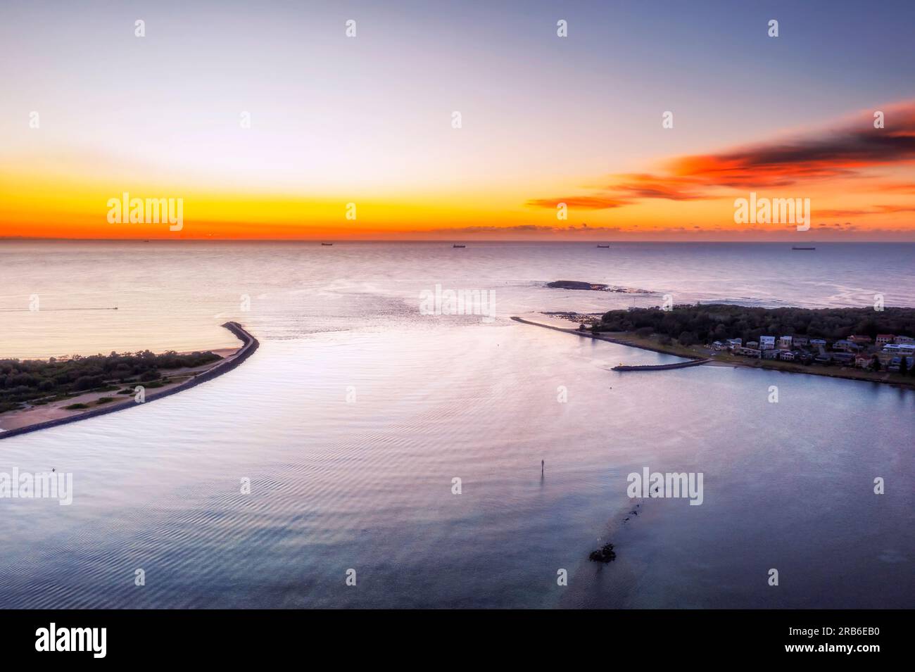 Swansea channel lagoon entering Pacific oceat at Swansea head - elevated aerial seascape at sunrise. Stock Photo