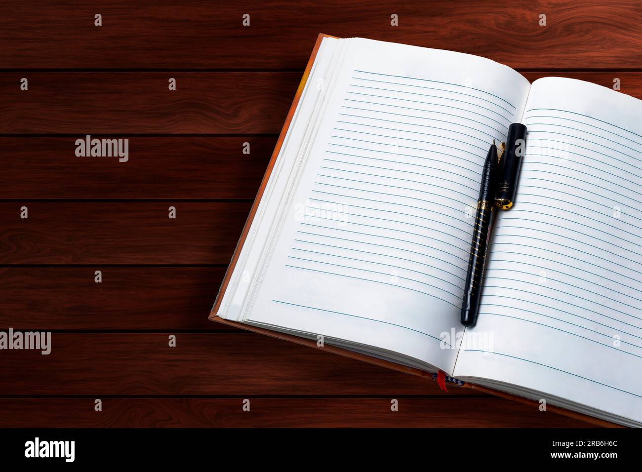 Open notebook with pen on wooden table. Top view Stock Photo