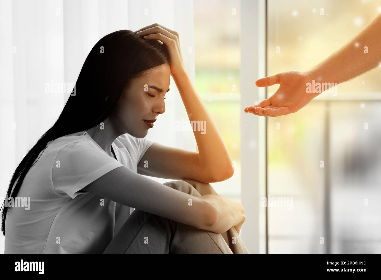 Empathy. Man offering helping hand to depressed woman indoors, closeup. Transition from black and white to color on photo as symbol of emotional suppo Stock Photo