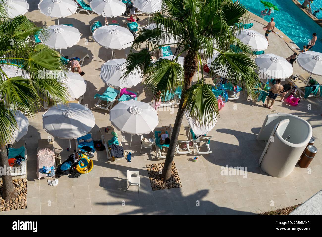 Hotels and pools at Palma de majorca, Mallorca hotels. Picture taken of people under sun umbrellas at summer time on resort or hotel. Resting and relaxing Stock Photo