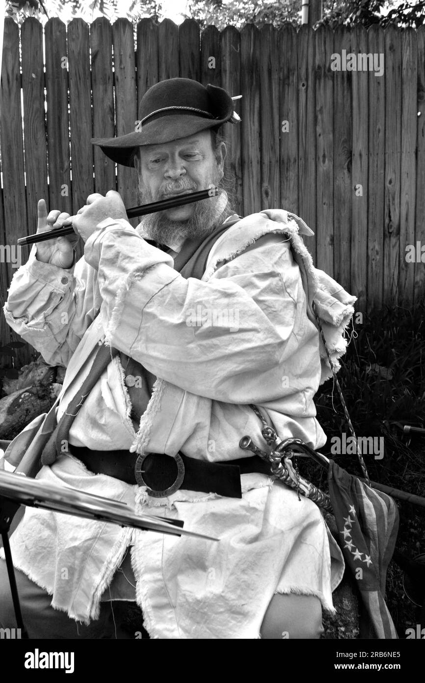 A 19th century pioneer reenactor talks with visitors while