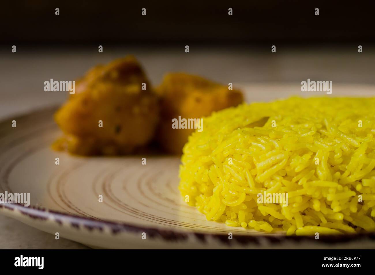 Pulav and potato curry served on a plate. Traditional Bengali basanti polao or sweet polao or fried rice served as offering to the deity during hindu Stock Photo