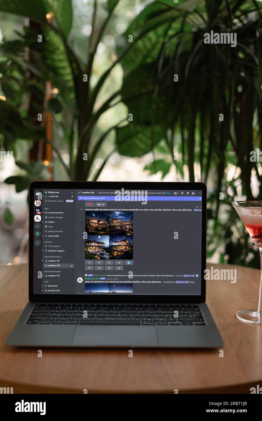 Odessa, Ukraine - June 14, 2023: Using Midjourney and discord site to generate visual content on laptop computer in cafe. Stock Photo