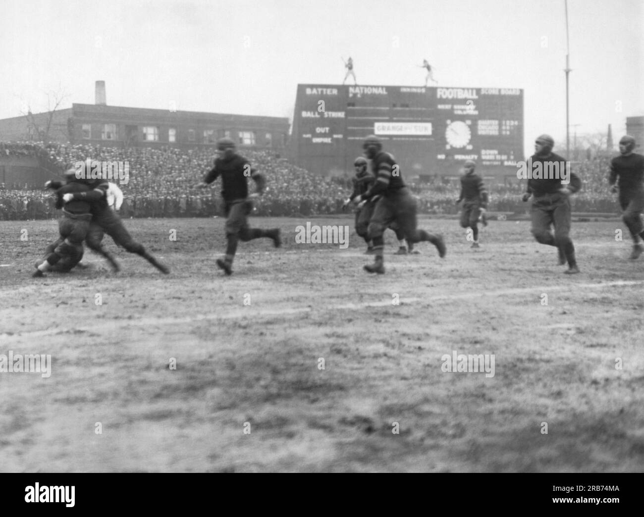 Chicago, Illinois:  November 27, 1925 Rookie Red Grange getting tackled at Cub's Park (later Wrigley Field) in his first professional game for the Chicago Bears, playing against their Southside rivals, the Chicago Cardinals. Grange received for his efforts the sum of $12,000 and a black eye. Stock Photo