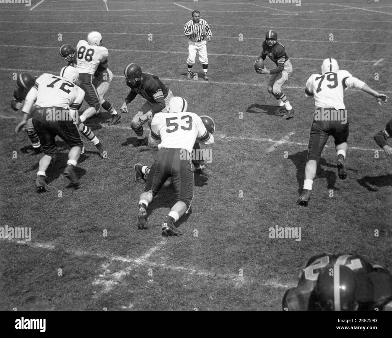 United States:  c. 1950 The quarterback faces a rush from the other team as he drops back to pass the football. Stock Photo
