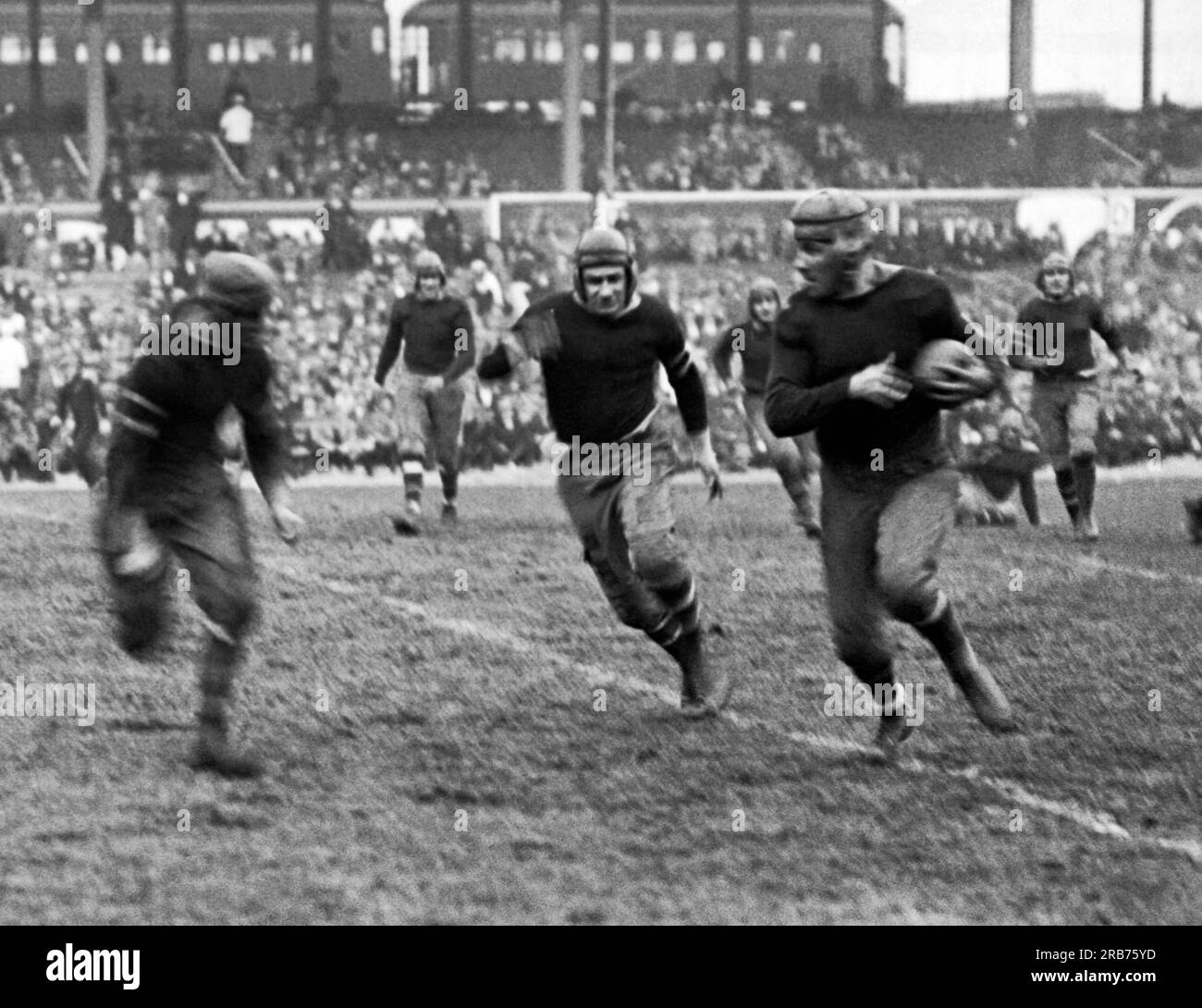 New York, New York: November 11, 1925 New York Giants rookie running back Heinie Benkert from Rutgers about to be tackled after a 30 yard run in a game aginst the Rochester Jeffersons. He went on to also play for the Pottsville Maroons and the Orange/Newark Tornadoes. Stock Photo