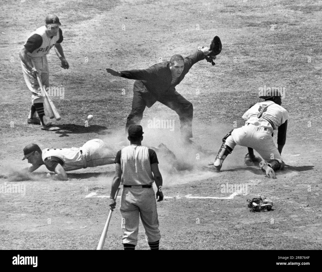 Los Angeles, California:  c. 1961 Umpire Frank Dascoli calls Bill Mazeroski of the Pittsburgh Pirates safe at the plate as the ball gets by L.A. Dodger catcher John Roseboro. Stock Photo