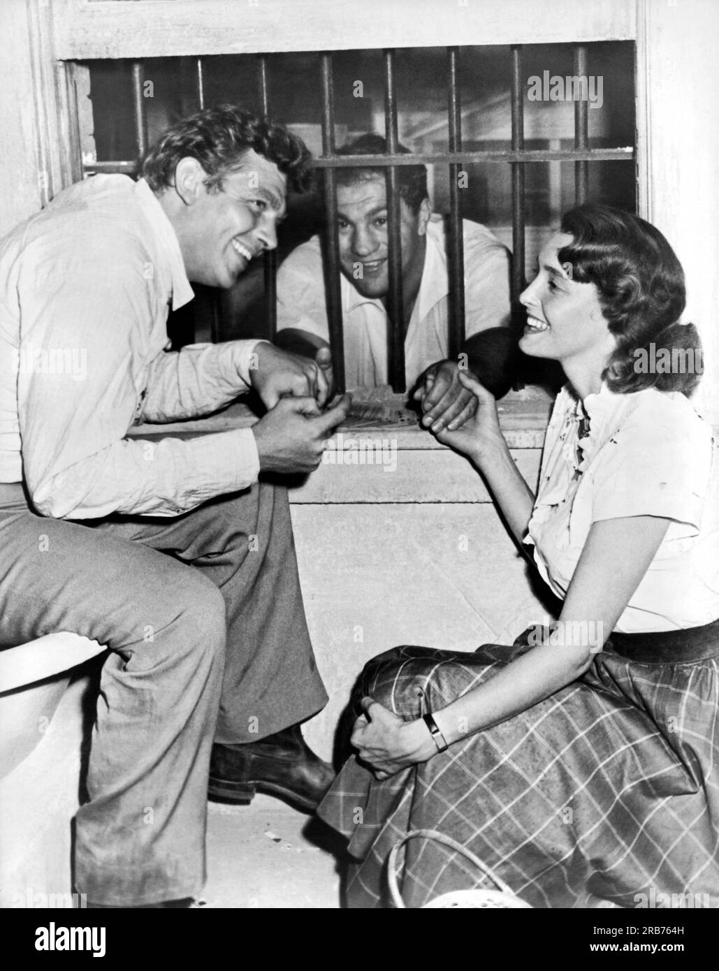 Hollywood, California:  1957. Retired heavyweight champion Rocky Marciano gets consoled on the set of 'A Face In The Crowd' by stars Andy Griffith and Patricia Neal. Marciano was visiting his friend Elia Kazan, director of the film. Stock Photo