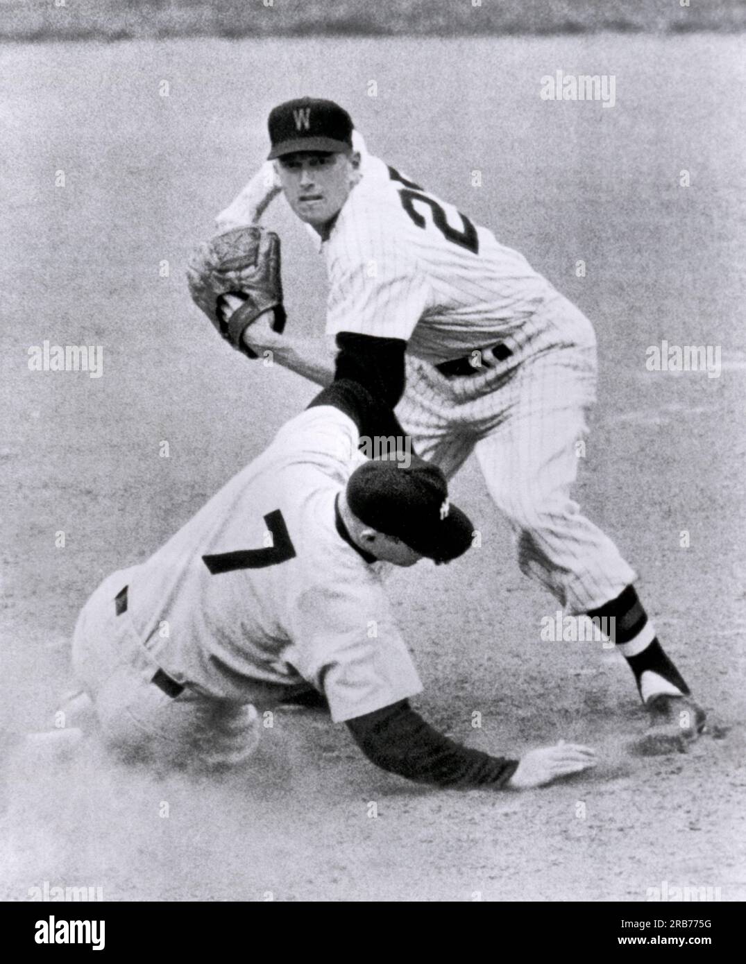 Washington, DC,  April 17, 1955. New York Yankee baseball player Mickey Mantle slides into second base for a force out by Washington Senator Bob Kline during a game against the Washington Senators. Stock Photo