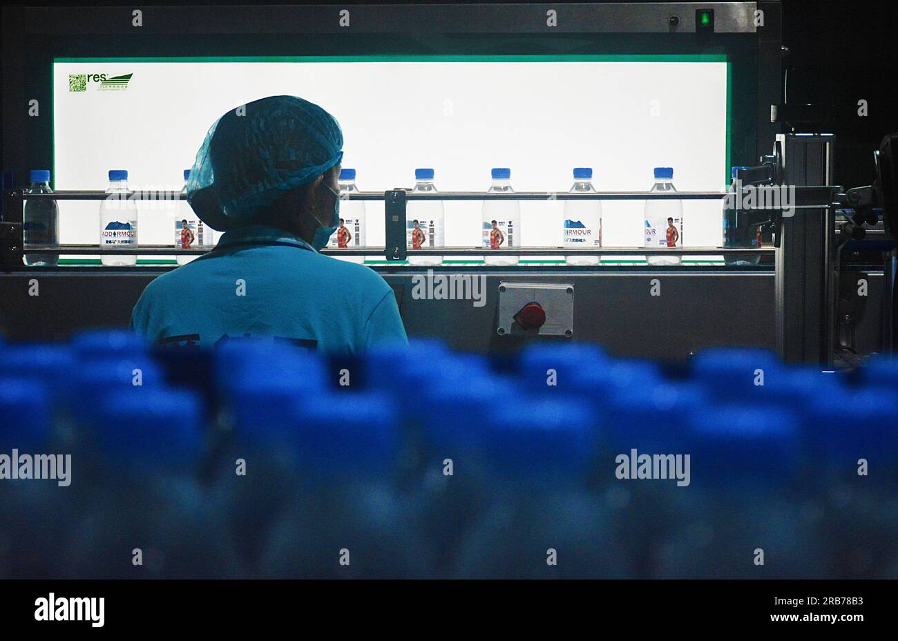 ANQING, CHINA - JULY 8, 2023 - Workers rush to make bottled water at the production workshop of a beverage company in the Economic development zone of Stock Photo