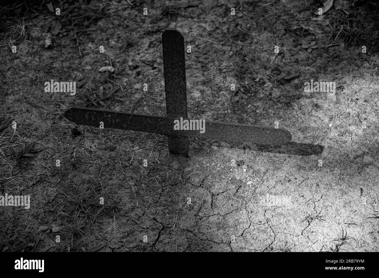 In the cemetary in Houma, this steel cross marking a grave has been buried over time from repeated floodings and hurricanes. Stock Photo