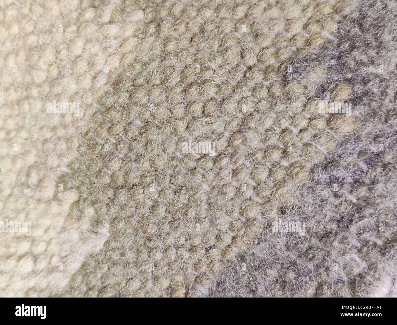Multicolored woolen knitted fabric with geometric pattern as a background, full frame. Natural wool fabric has a soft and slightly fuzzy texture Stock Photo