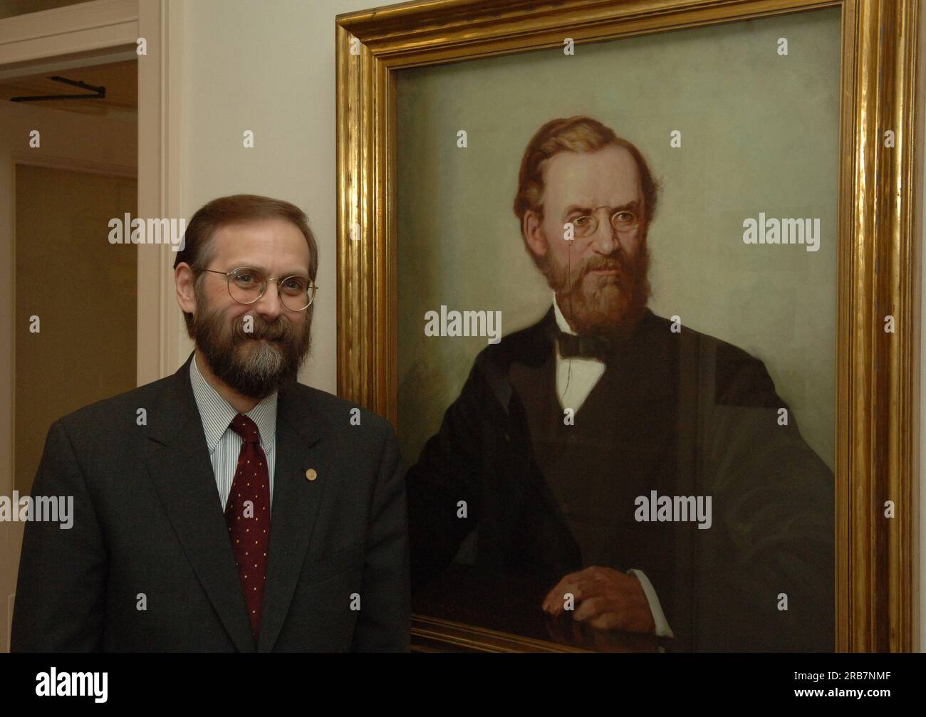 Office of Budget Director John Trezise, posing next to painted portrait of former Secretary of the Interior (1877-1881) Carl Schurz Stock Photo