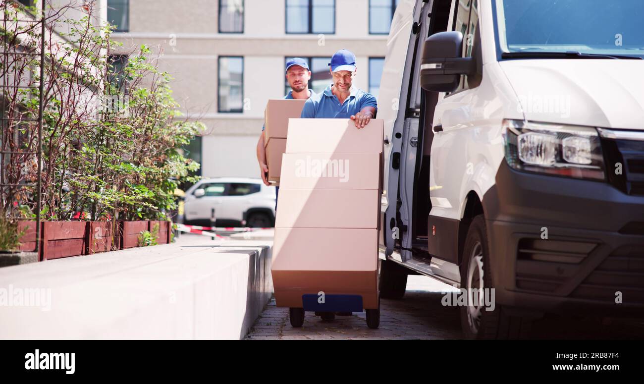 Delivery Man With Handtruck. Courier Near Car Truck Stock Photo
