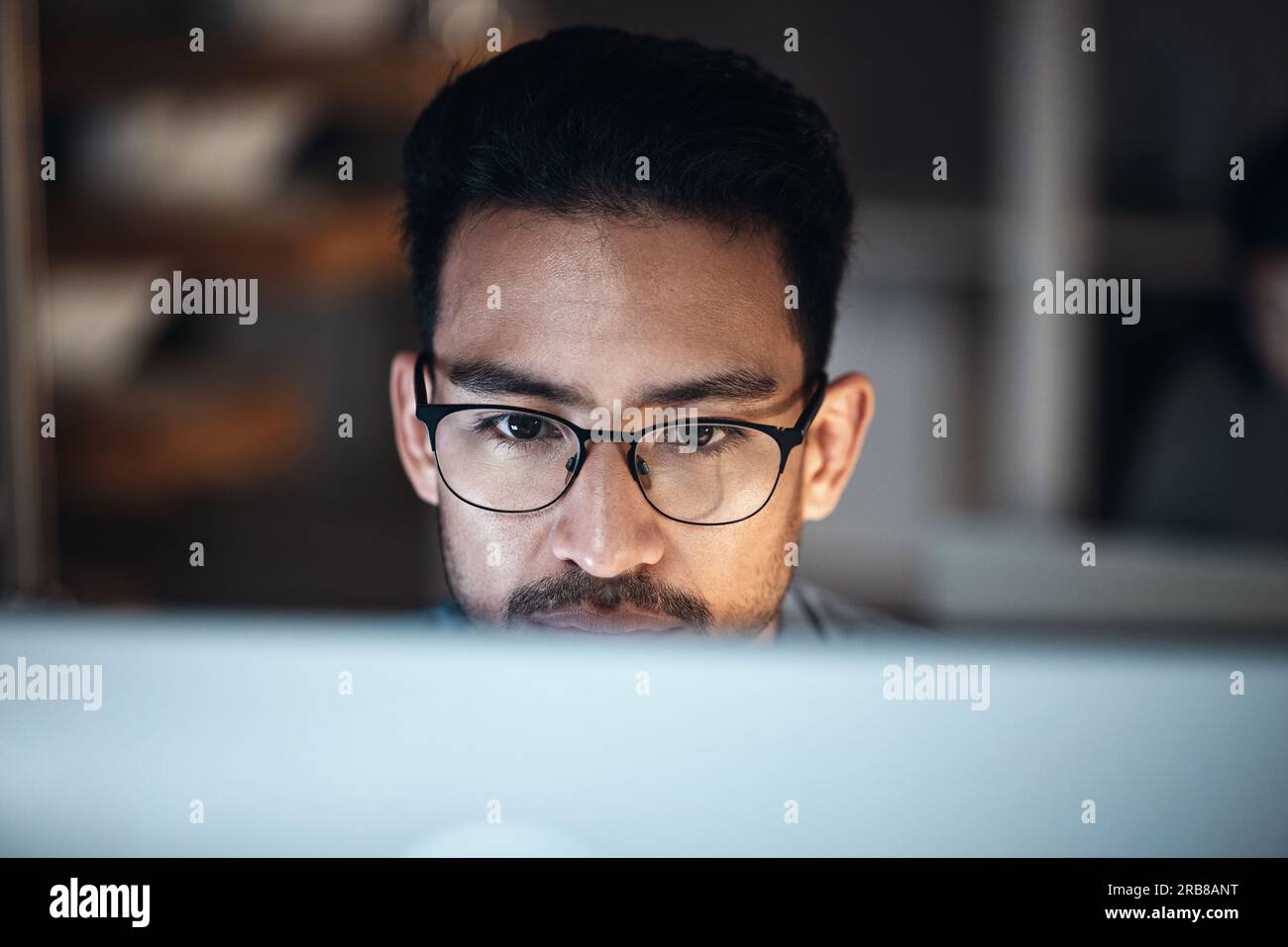 Computer, research and man in glasses for software development, night programming and cybersecurity. Reading, focus and person or programmer with data Stock Photo