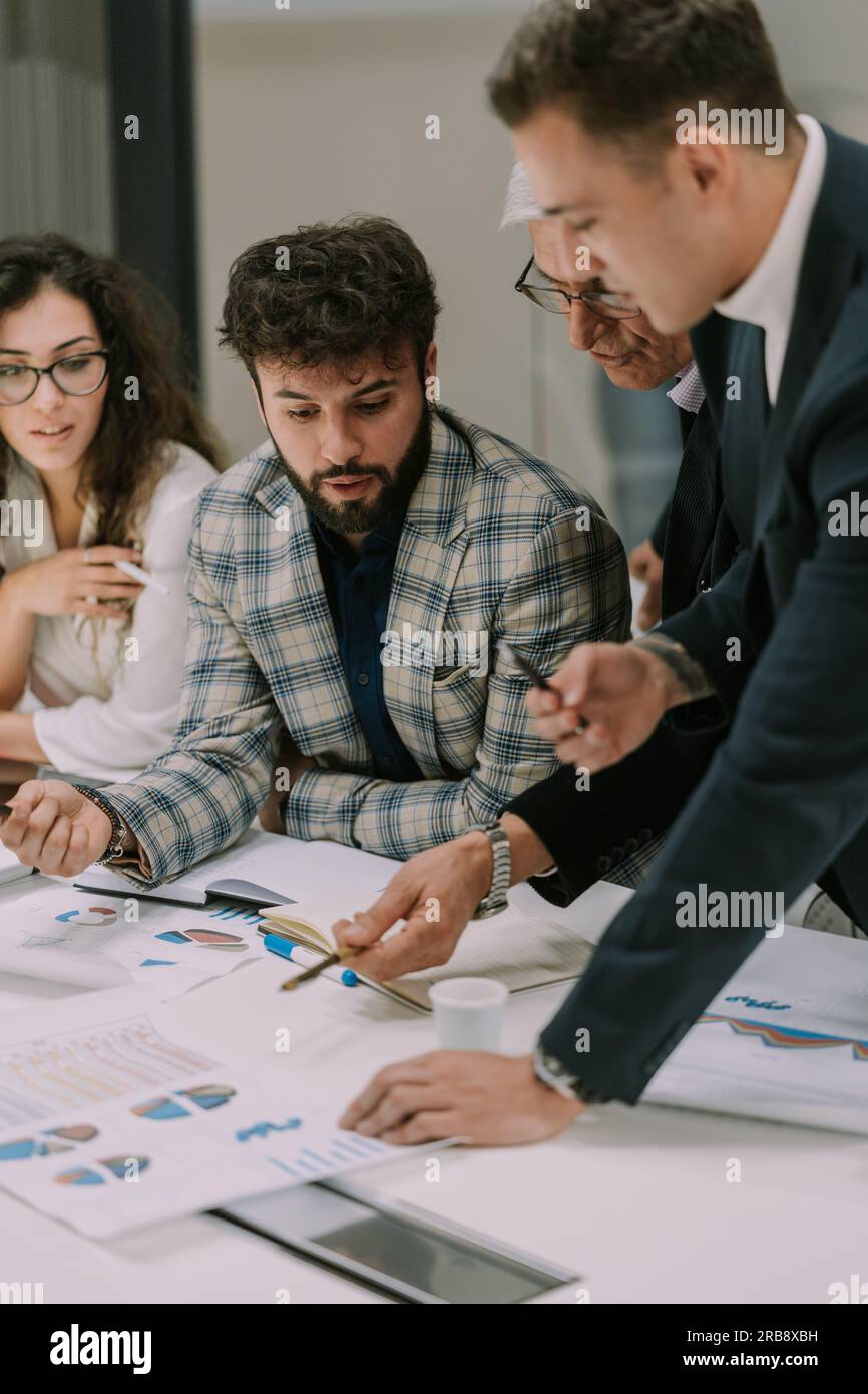 Three junior employees listening to their boss giving them advices for