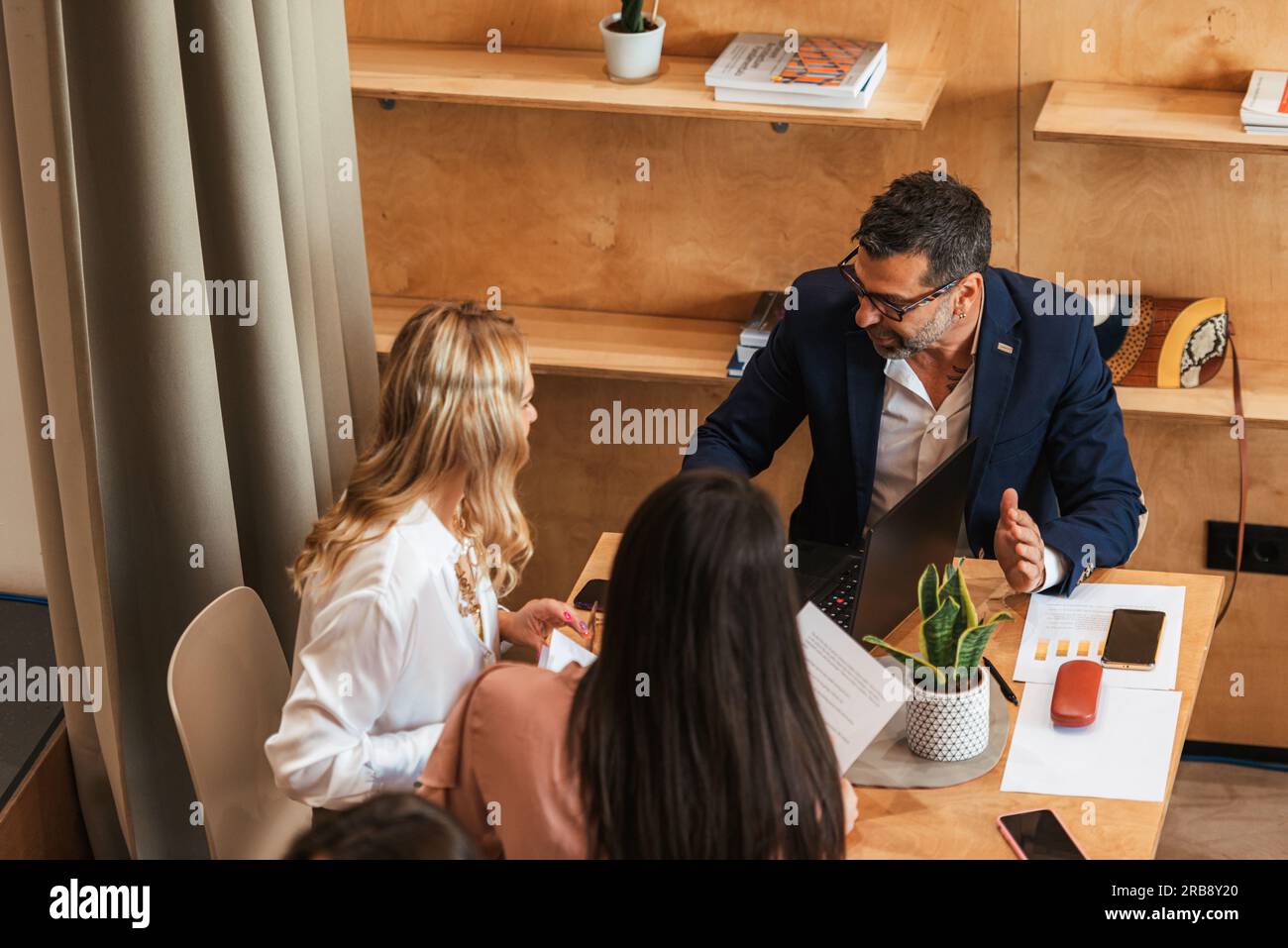 Friends working together and talking at the cafe Stock Photo