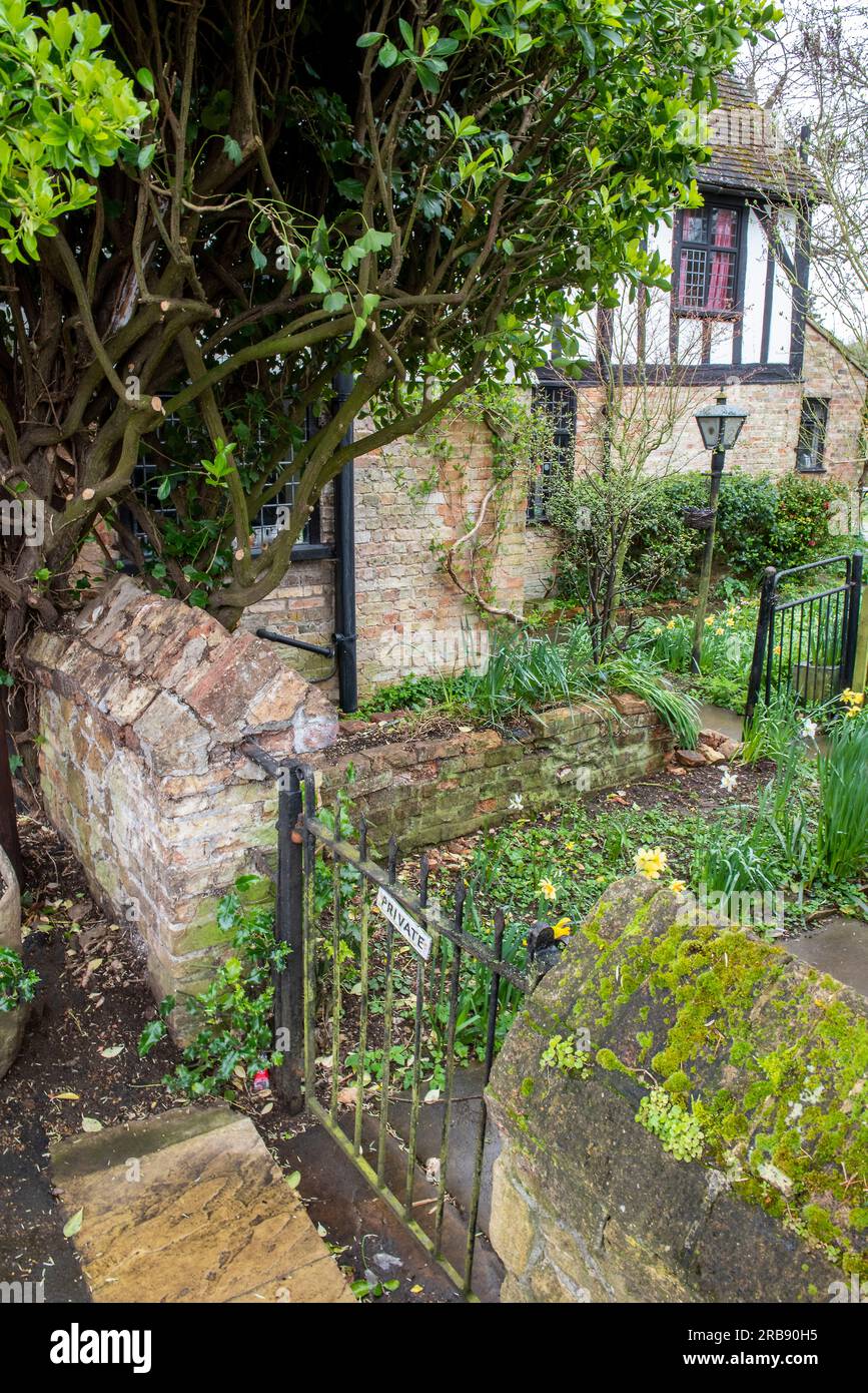 old english country cottage in the tudor style, old garden wall and