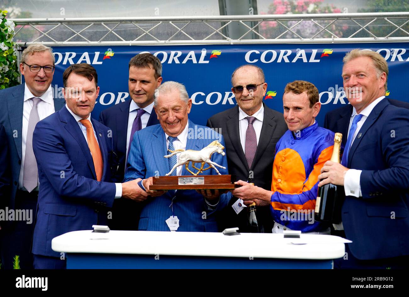 Jockey Ryan Moore, trainer Aidan O'Brien and the winning connections pose for a photo with the trophy after Paddington wins the Coral-Eclipse during Coral-Eclipse day of the Coral Summer Festival at Sandown Park Racecourse, Esher. Picture date: Saturday July 8, 2023. Stock Photo