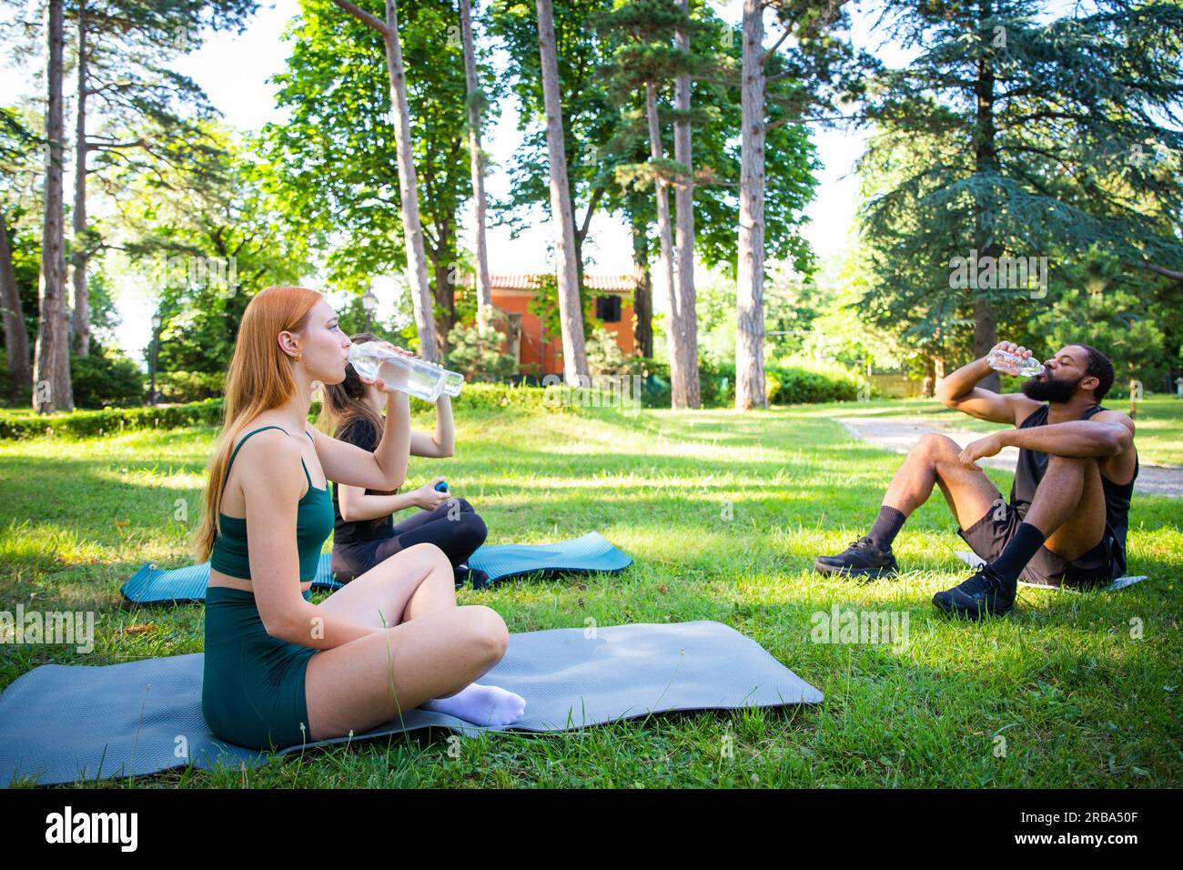 During a workout a group of sportspeople drink water, hydration in sport Stock Photo