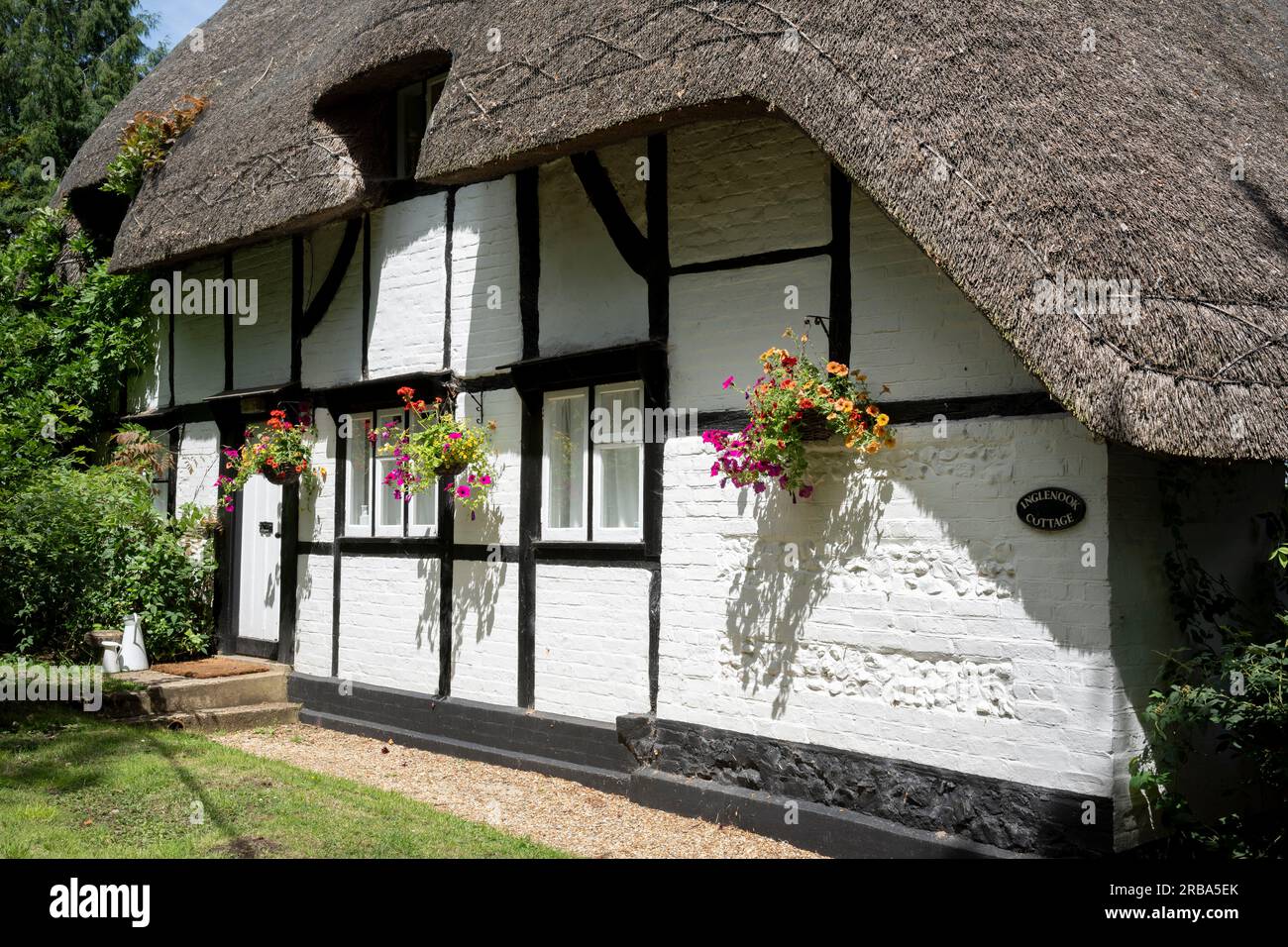 The thatched 17th century Grade II listed 'Inglenook Cottage', a timber-frame village house in rural Hampshire, on 6th July 2023, in Longparish, Hampshire, England. Stock Photo