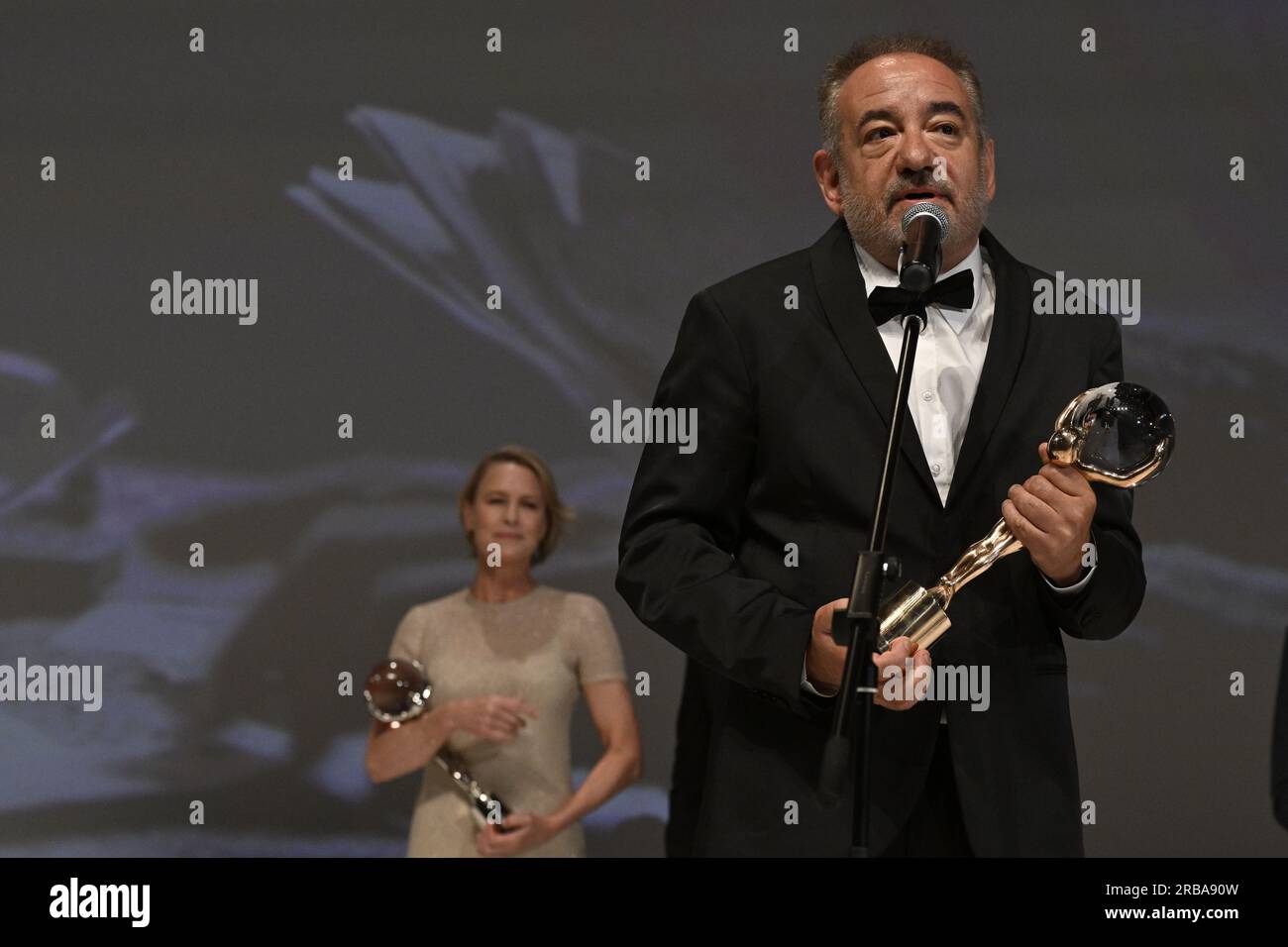 Karlovy Vary, Czech Republic. 08th July, 2023. The last day of the 57th Karlovy Vary International Film Festival, July 8, 2023. Bulgarian director Stephan Komandarev receives the Crystal Globe at the closing ceremony for his film Blazha's Lessons. In the background is American actress Robin Wright, who received the President's Award at the Karlovy Vary International Film Festival. Credit: Katerina Sulova/CTK Photo/Alamy Live News Stock Photo