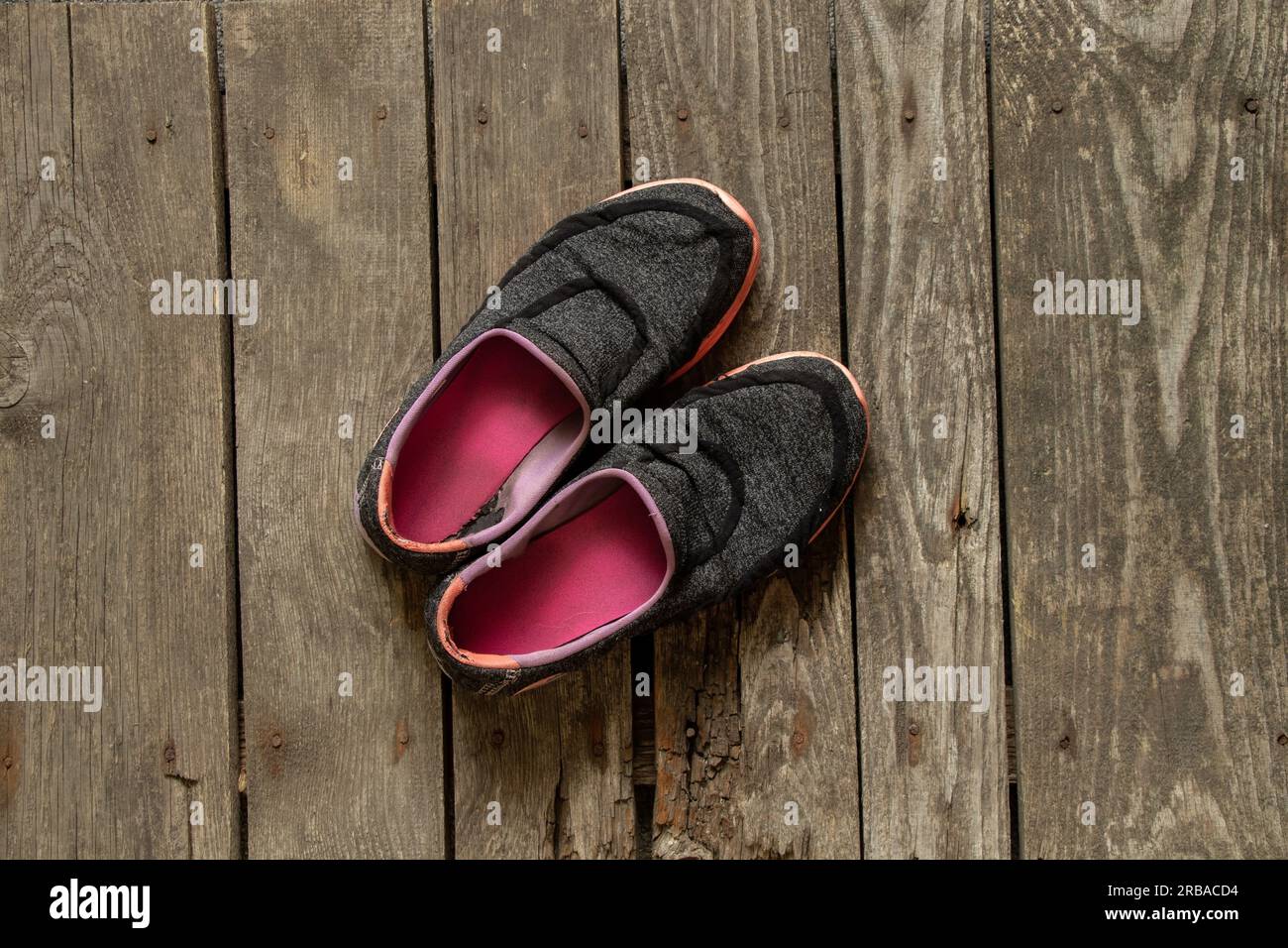 dirty old women's sneakers stand on the wooden floor of the house Stock ...