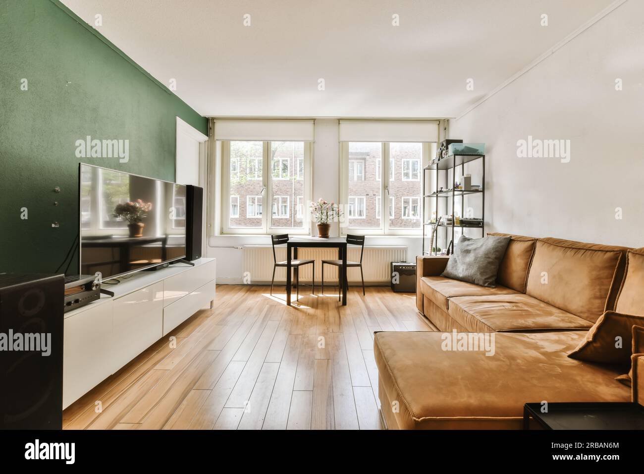 a living room with wood flooring and green walls, including a brown ...