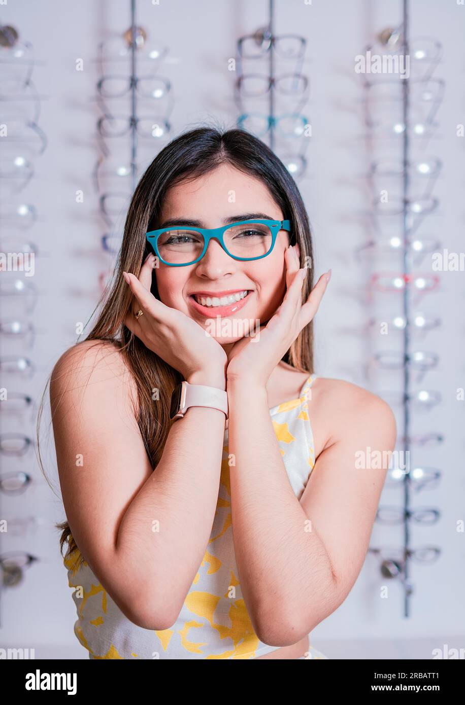 Portrait of a happy female customer wearing glasses in an eyewear store. Smiling girl wearing glasses in an eyeglass store Stock Photo