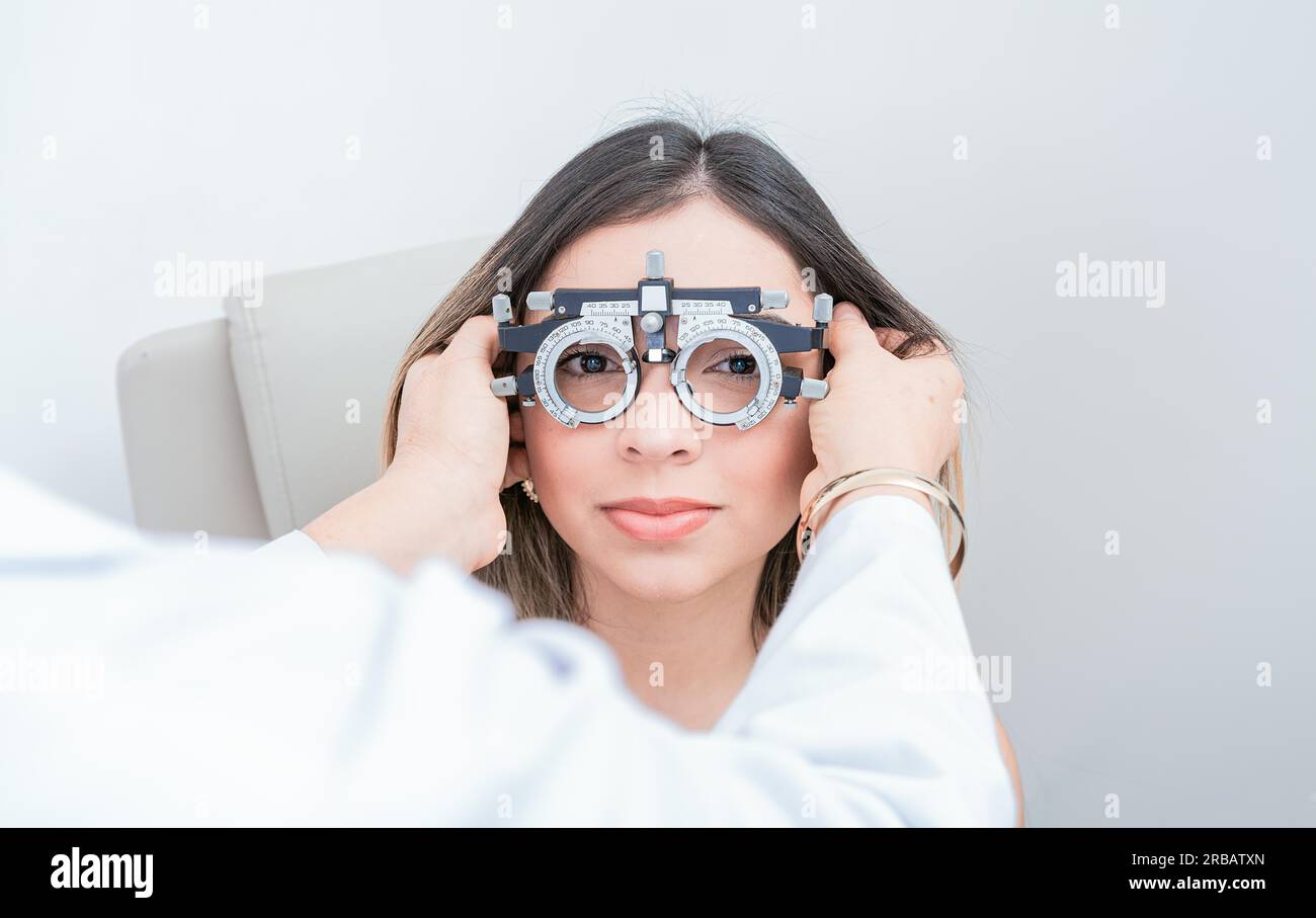 Ophthalmologist examining patient with optometrist trial frame. Doctor