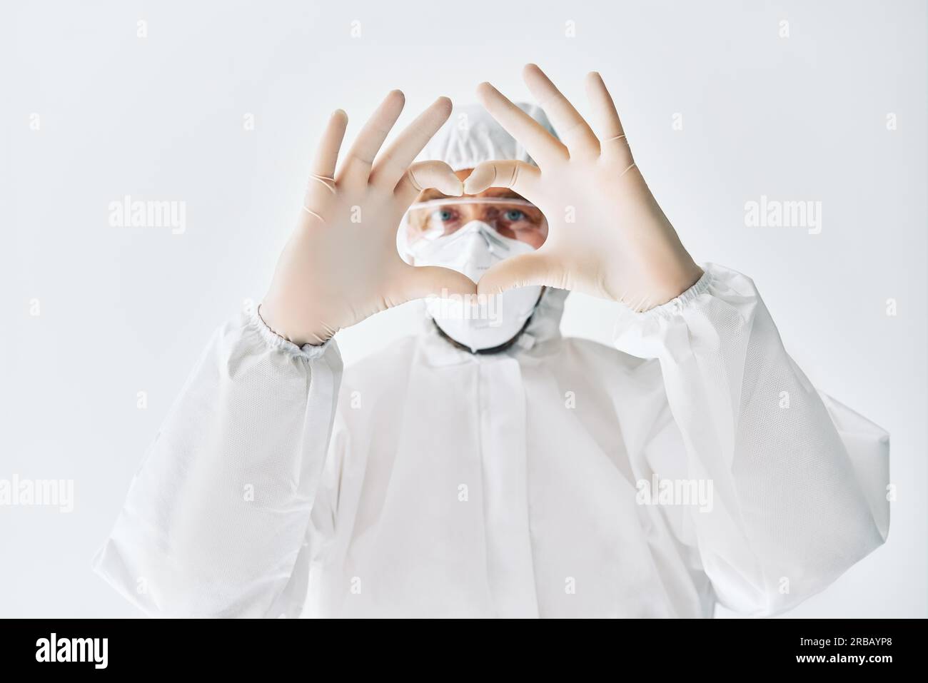Doctor making heart shape symbol with hands wearing protective medical ...