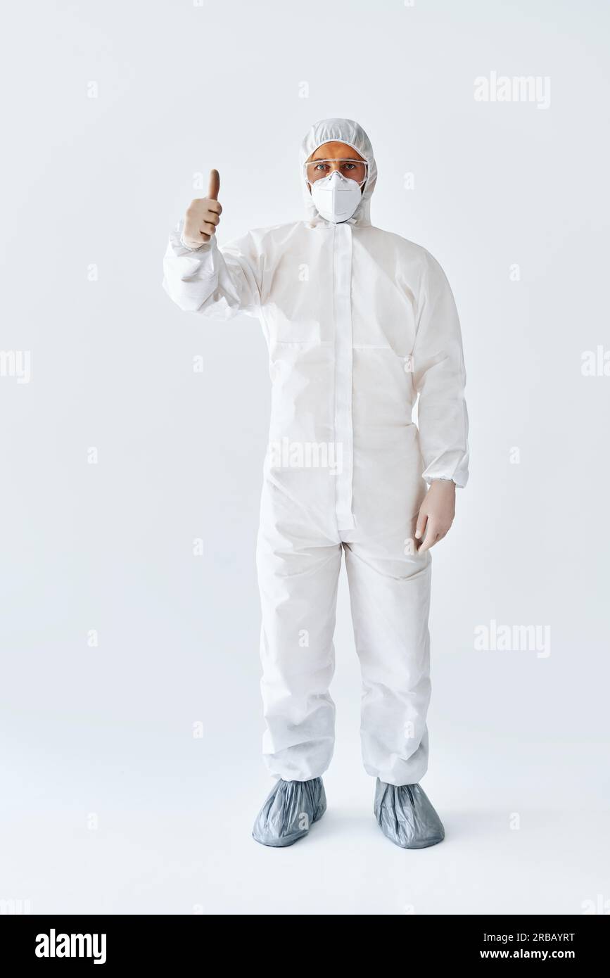 Doctor in protective medical suit showing thumbs up. success concept Full length portrait Stock Photo