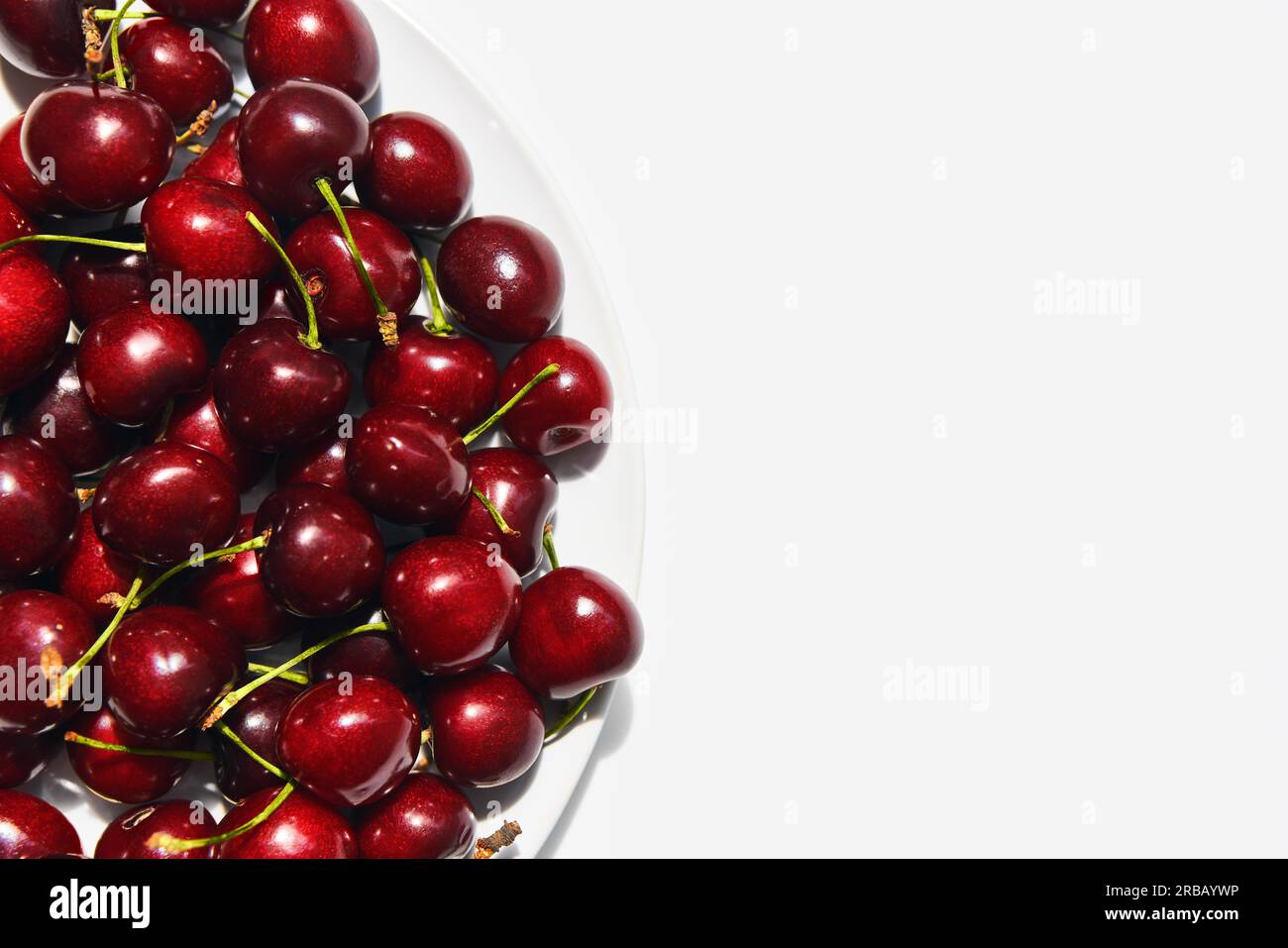 Ripe sweet cherries on plate isolated on white background with copy space. Healthy food, summer concept Stock Photo