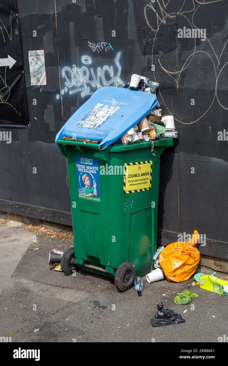 Bristol, England - June 16th 2023: Overflowing recycle bin on street with Council Aware sticker Stock Photo