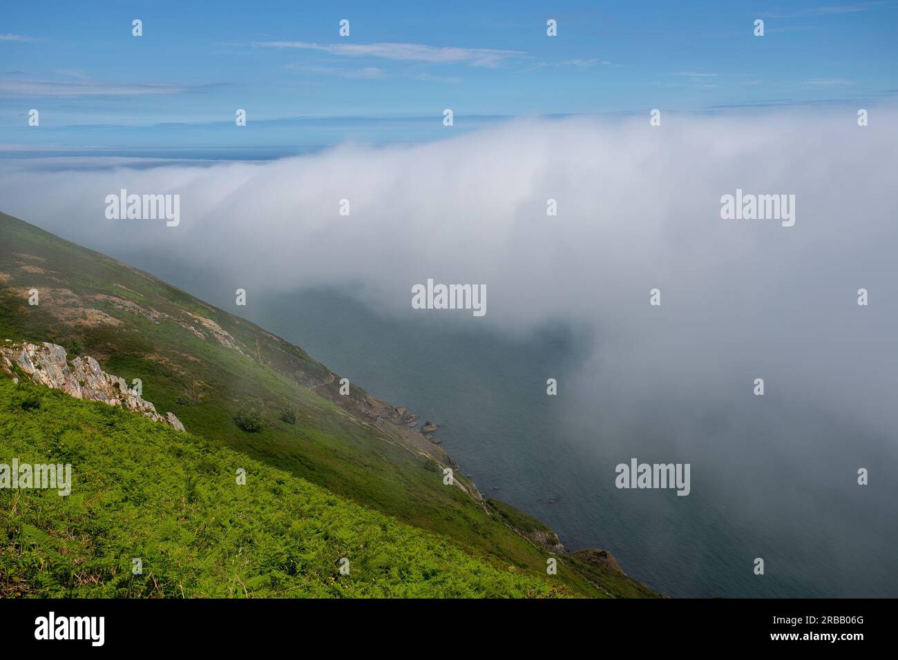 View from the summit of Bray Head with sea mist rolling over the coastline Stock Photo
