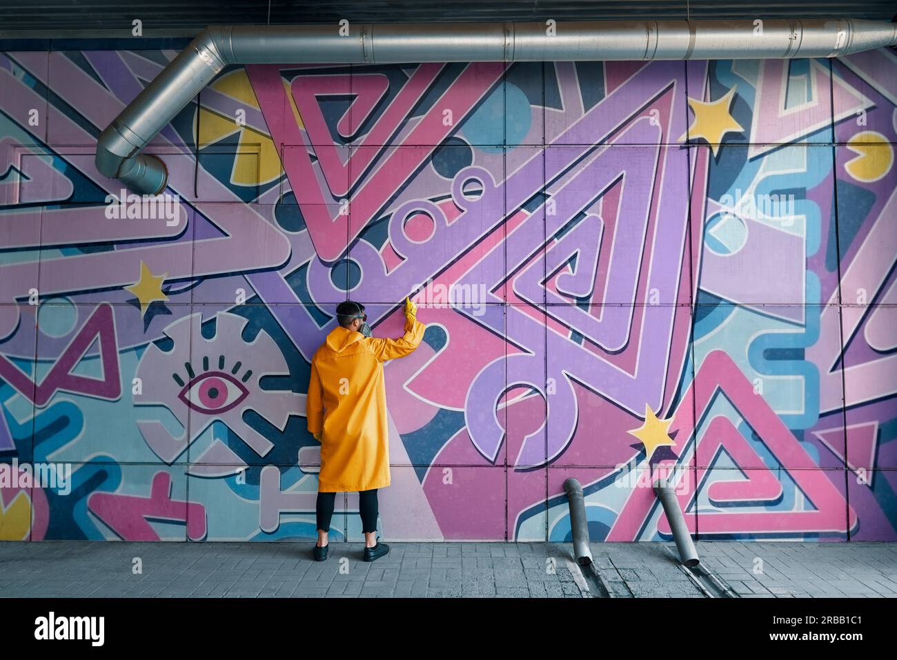 Street artist painting colorful graffiti on wall Modern art, urban ...