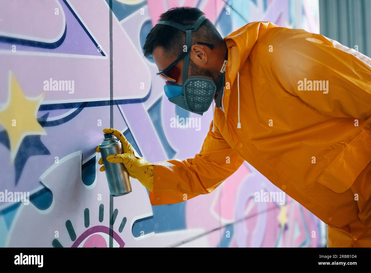 Street artist painting colorful graffiti on wall. Modern urban art ...