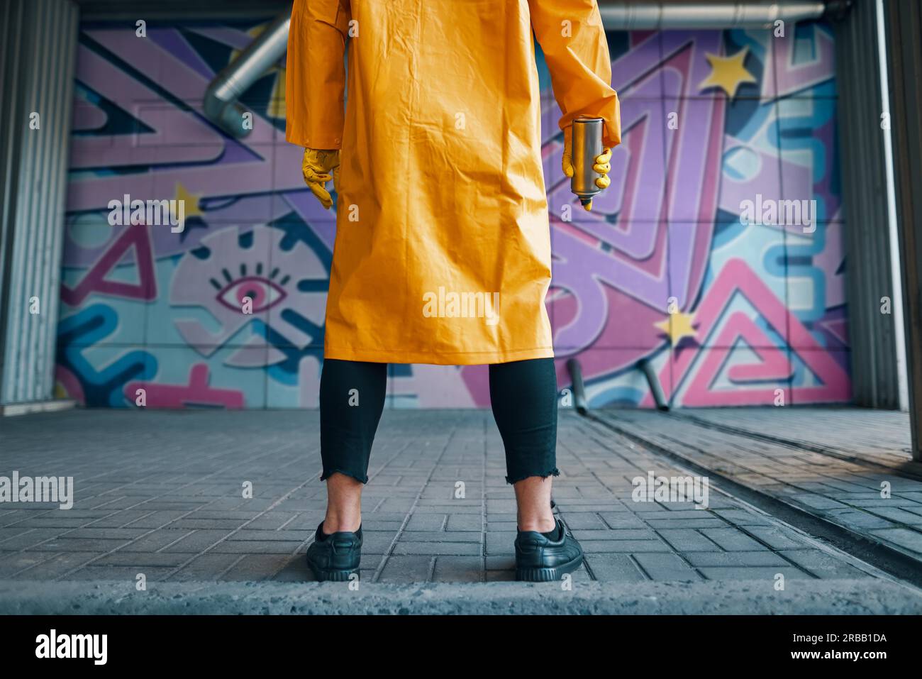 Cropped image of street artist with spray paint can in hand standing ...