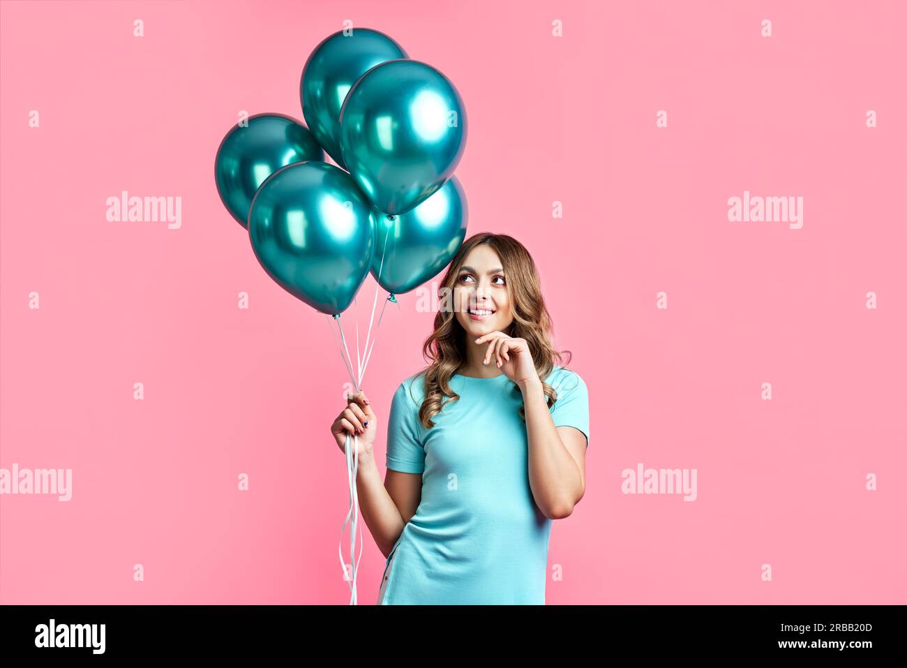Happy pretty woman with blue balloons in hands on pink background. party concept Stock Photo