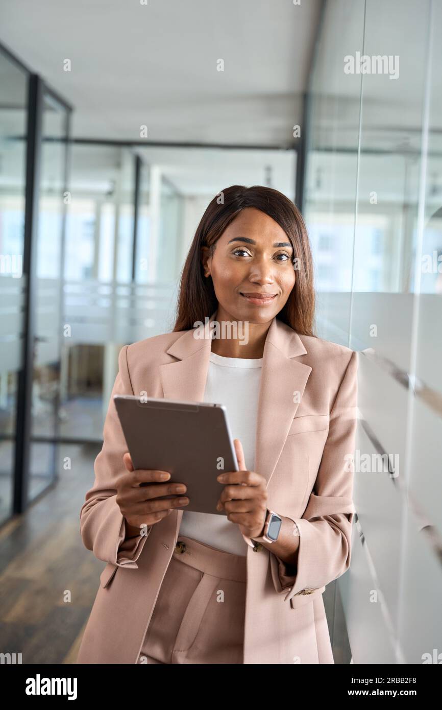 Young professional business woman holding tablet in office, vertical portrait. Stock Photo