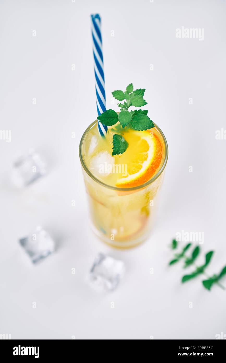 Cocktail with orange juice, mint and ice cubes on white background