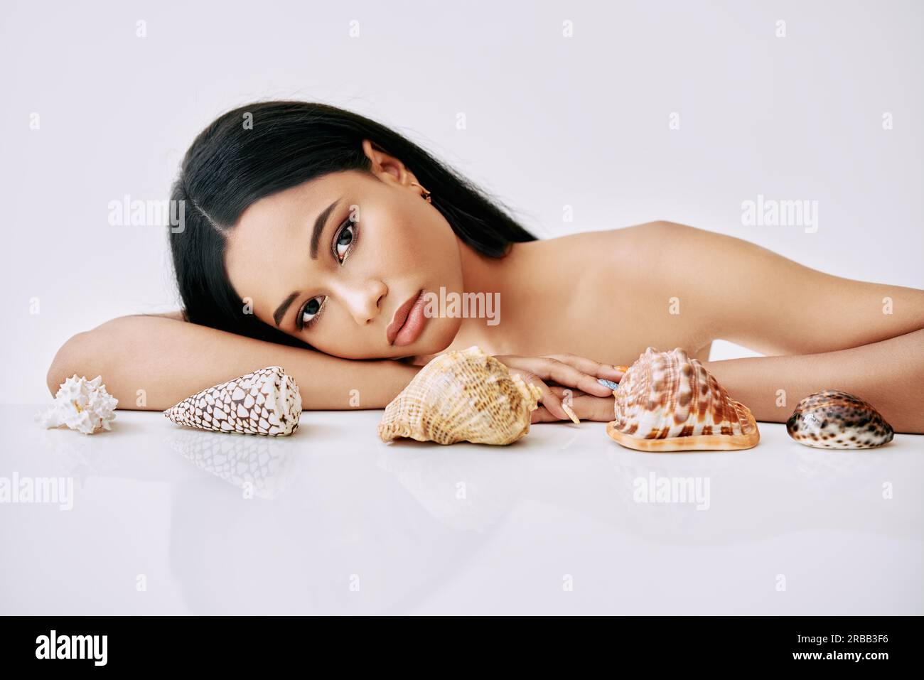 Beautiful african american woman with different seashells on white background. Beauty female portrait Stock Photo