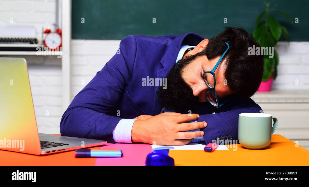Back to school. Sleeping male student in classroom. Knowledge, education and learning concept. Bearded man in glasses sleep in classroom. Hard work Stock Photo